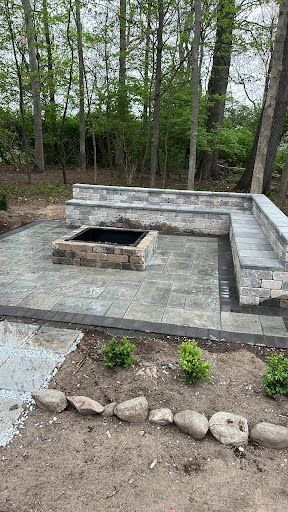 Custom firepit with stone seating walls on a paver patio