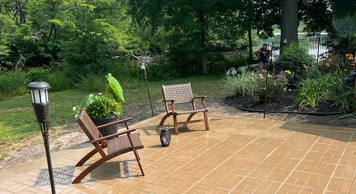Paver patio with seating overlooking a wooded lake